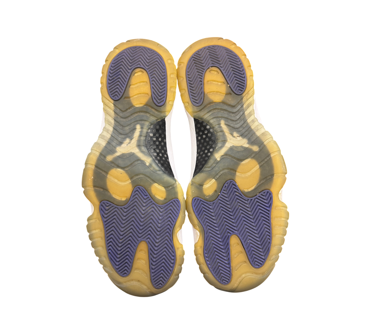Genesis Boutique Jordan 11 Concord sneakers showing yellowed translucent outsoles with purple herringbone traction