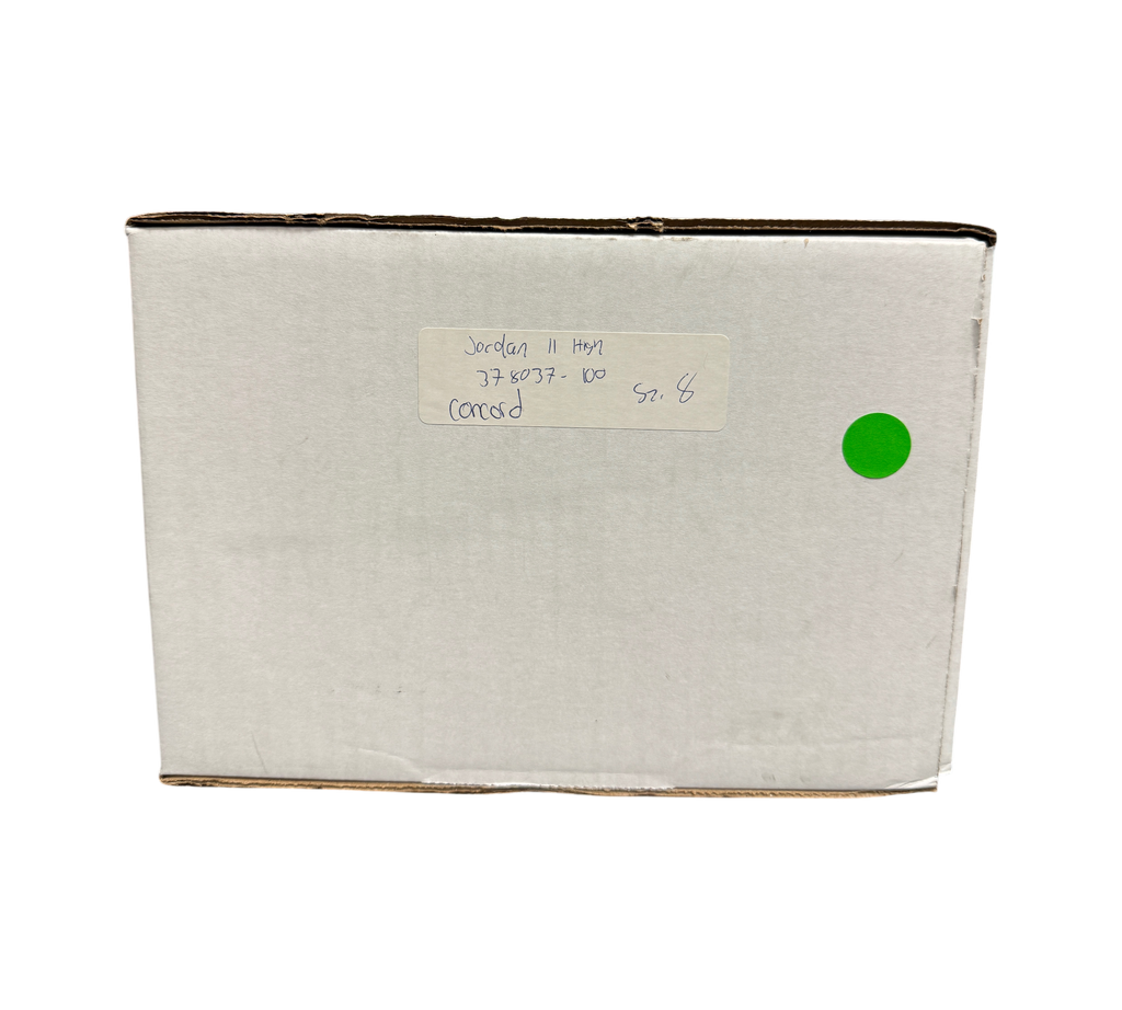 Genesis Boutique white cardboard shipping box with handwritten Jordan 11 Concord label and green sticker