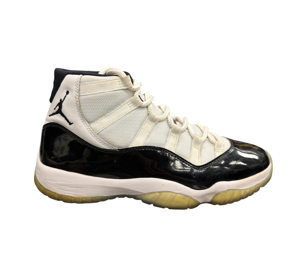 Genesis Boutique Jordan 11 Concord sneaker in white and black patent leather with a translucent yellowed outsole.