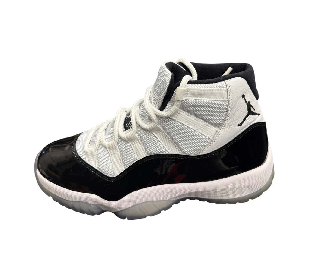 Genesis Boutique Jordan 11 Concord sneakers featuring white mesh upper, black patent leather mudguard, and icy sole.