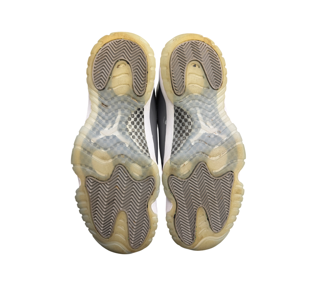 Genesis Boutique used Jordan 11 Cool Grey sneakers showing the translucent outsoles and carbon fiber plate detail.