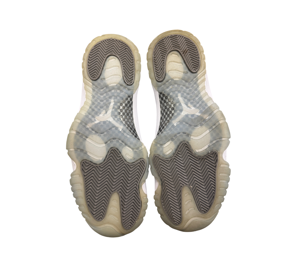 Genesis Boutique Jordan 11 Cool Grey sneakers showing the translucent grey rubber outsoles with herringbone tread.