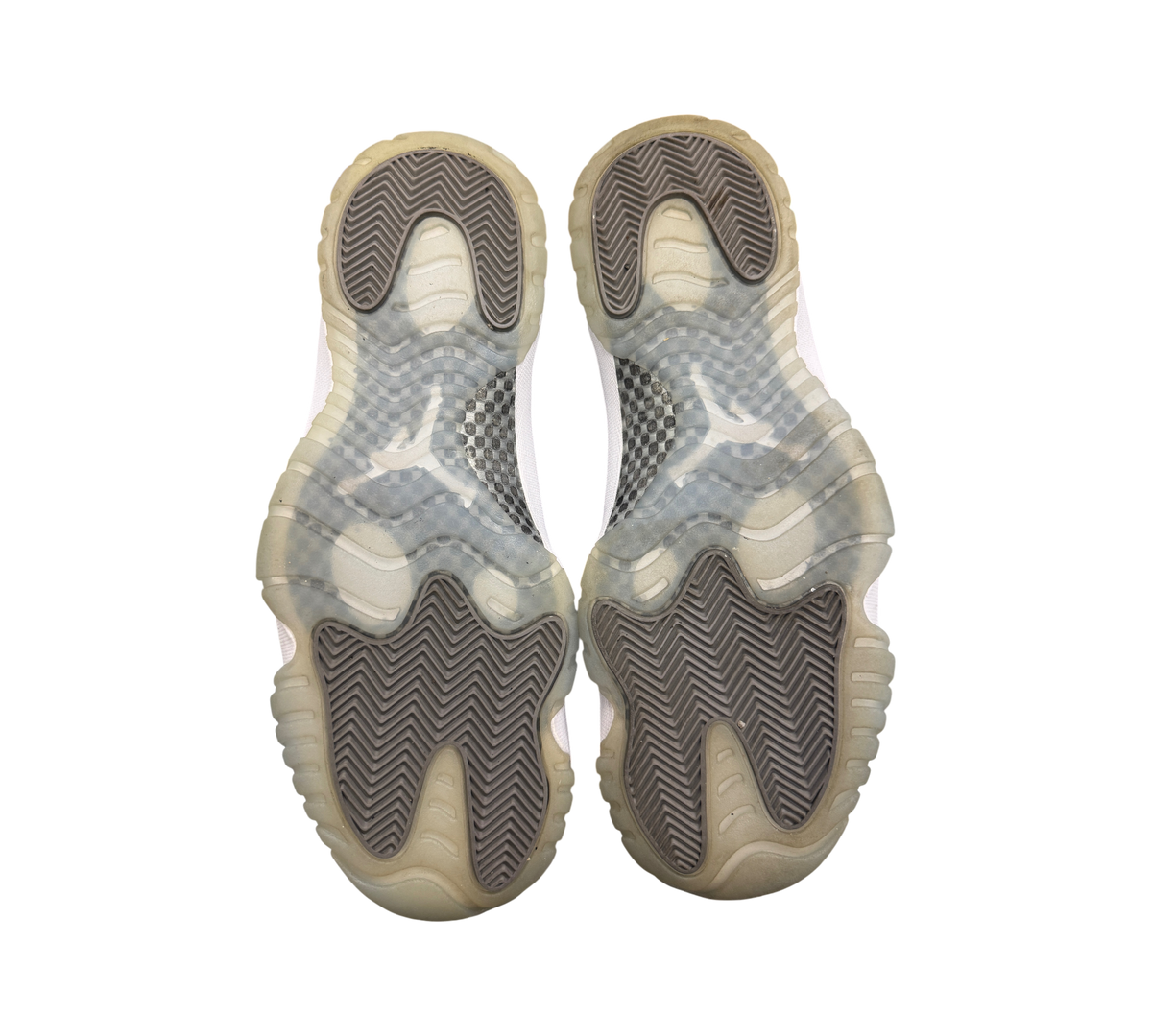 Genesis Boutique Jordan 11 Cool Grey sneakers showing the translucent grey rubber outsoles with herringbone tread.