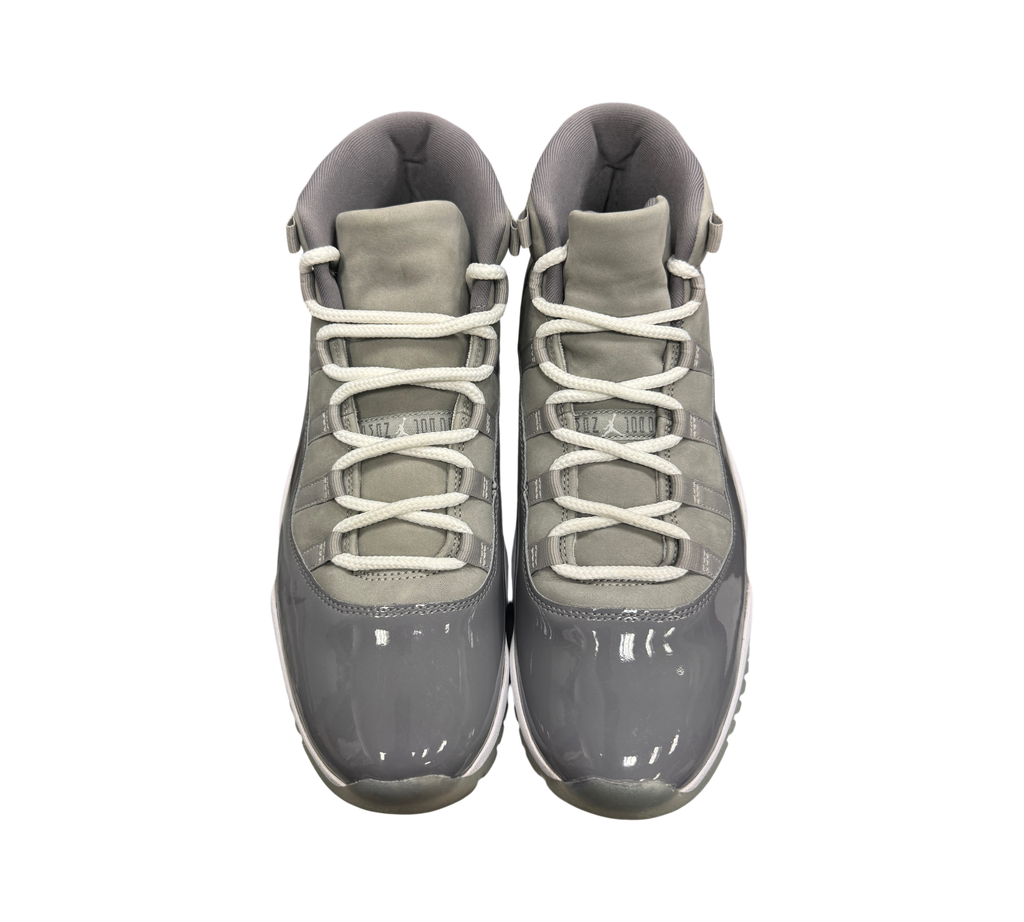 Genesis Boutique Jordan 11 Cool Grey sneakers featuring grey patent leather, suede upper, and white laces.