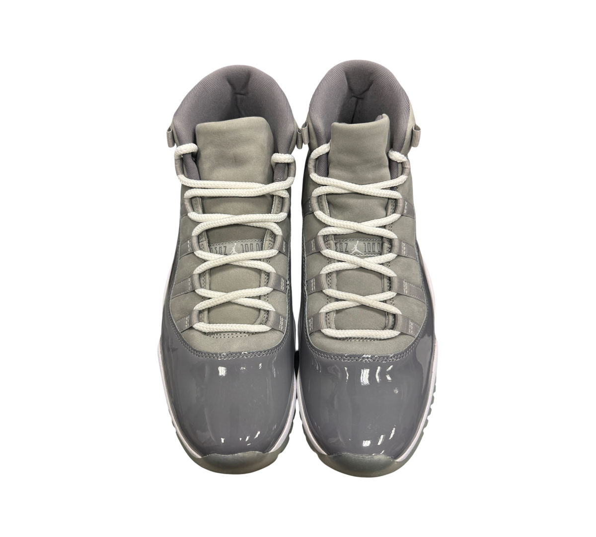 Genesis Boutique Jordan 11 Cool Grey sneakers featuring grey patent leather, suede upper, and white laces.