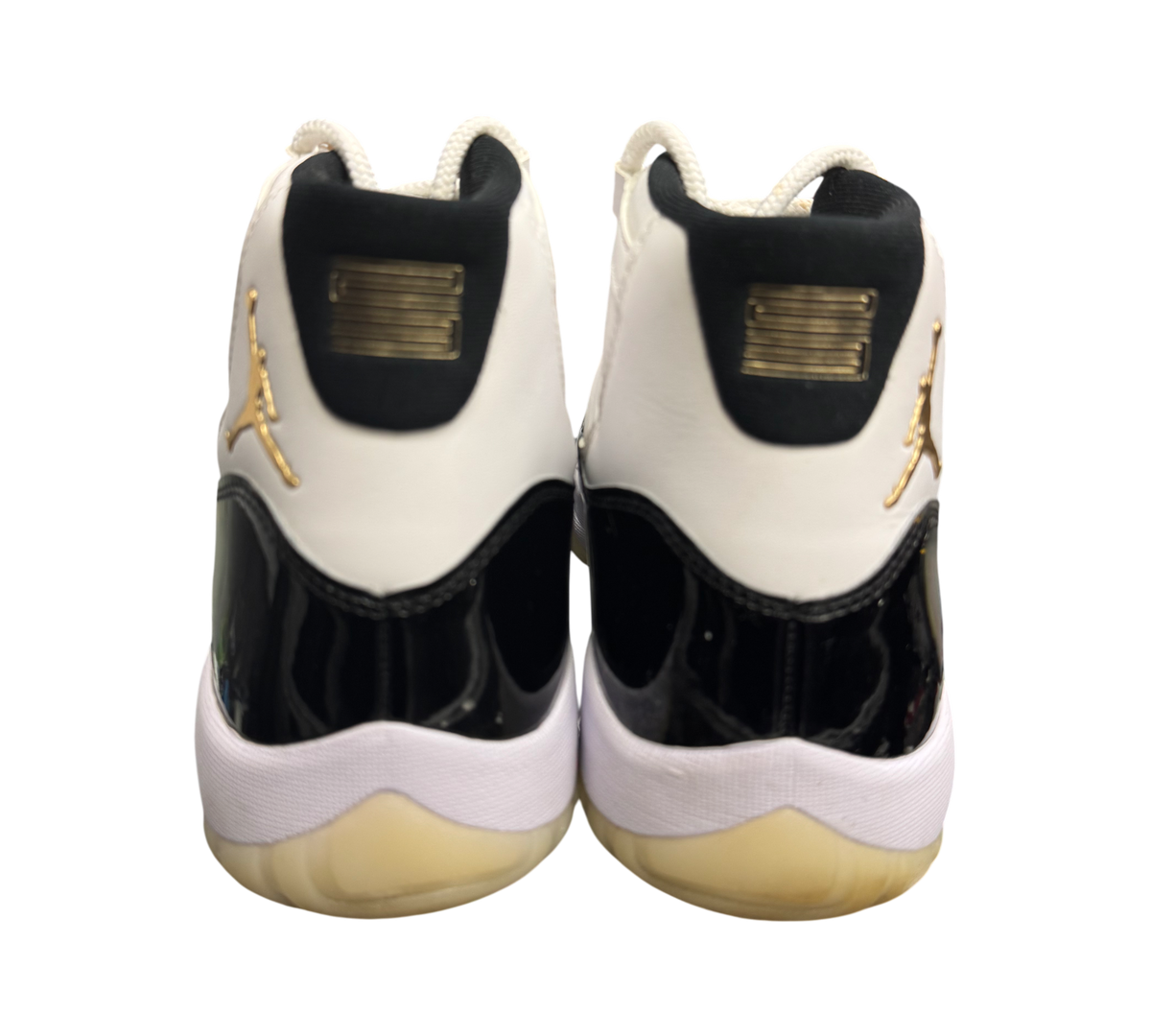 Genesis Boutique Jordan 11 DMP Gratitude sneakers with white, black, and gold accents. Patent leather details.