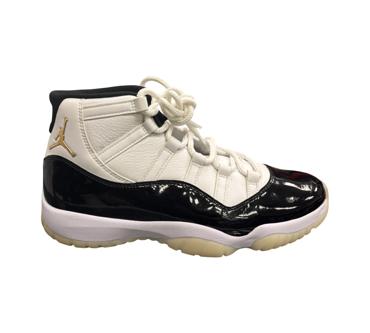 Genesis Boutique Jordan 11 DMP Gratitude sneakers in white leather with black patent leather accents and gold Jumpman logo.