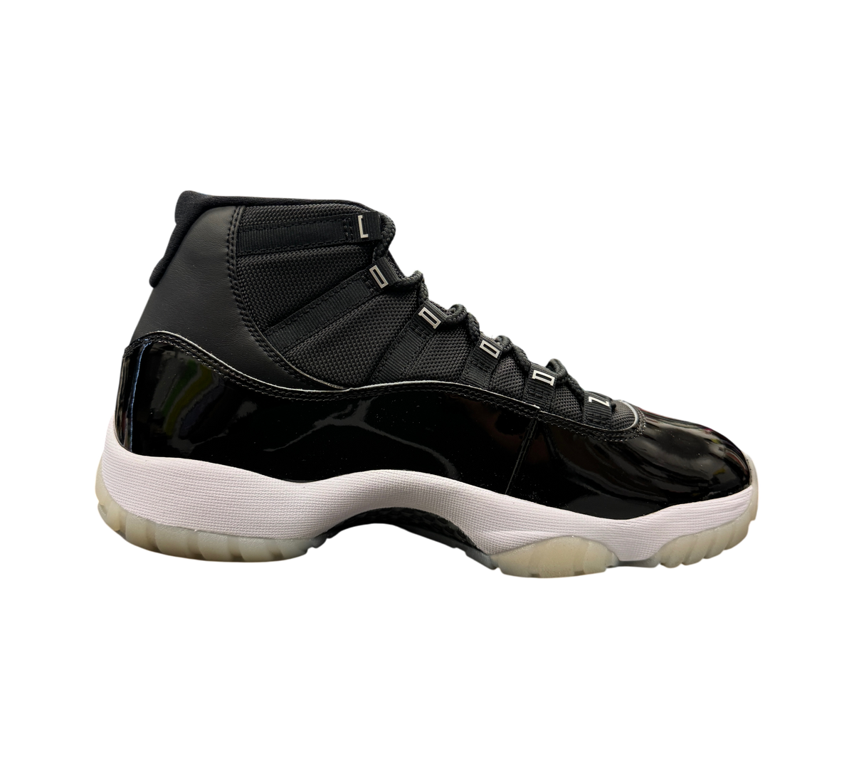 Genesis Boutique Jordan 11 Jubilee sneakers in black patent leather and mesh with a white midsole and translucent sole.