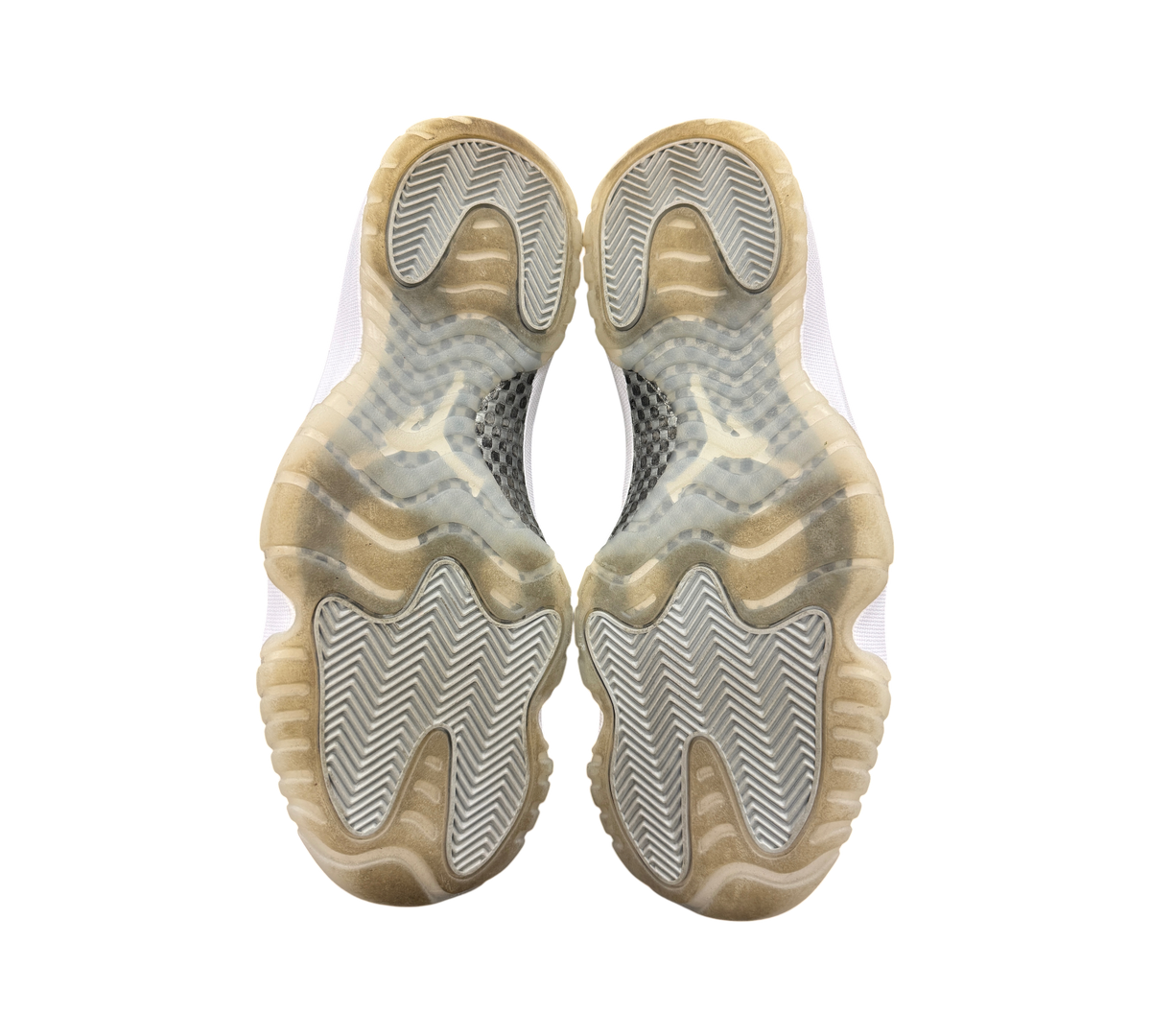 Genesis Boutique Jordan 11 Jubilee sneakers showing the translucent rubber outsoles with herringbone traction pattern