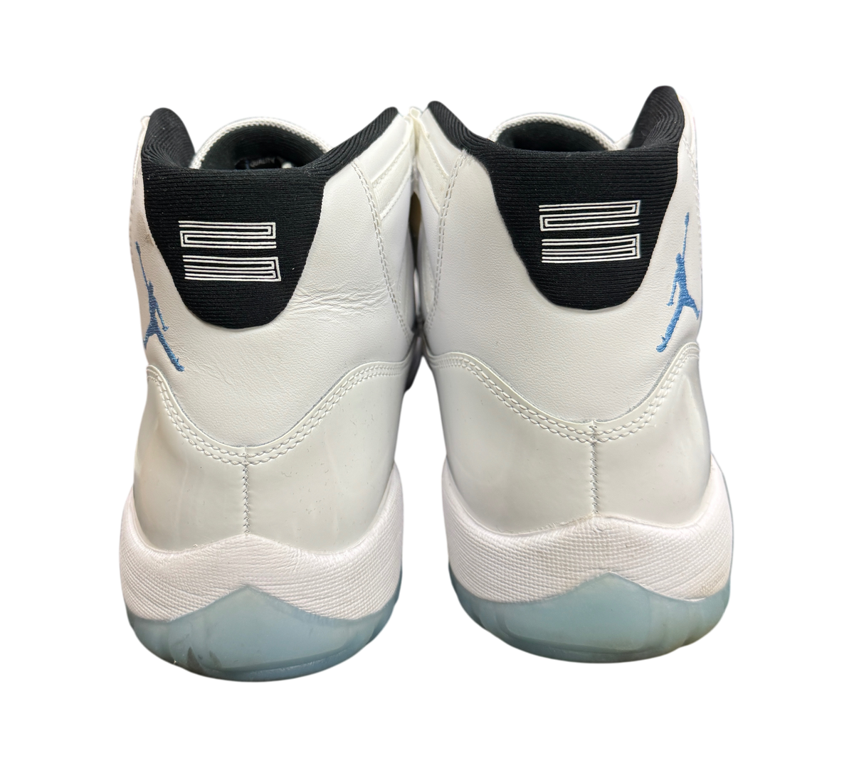 Genesis Boutique Jordan 11 Legend Blue sneakers showing white leather heels, black collars, and light blue Jumpman logos.