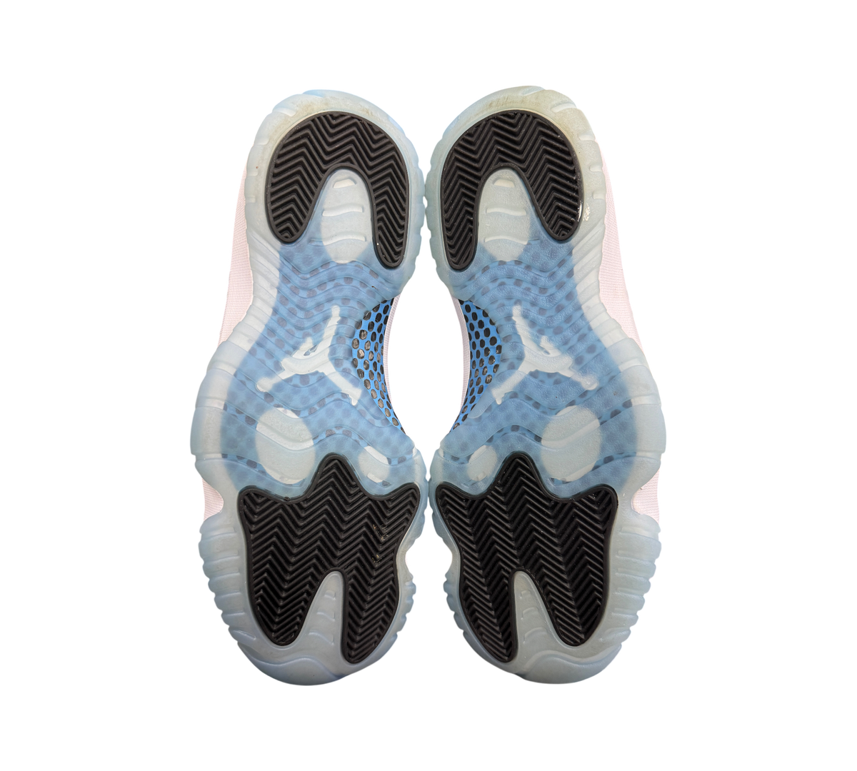Genesis Boutique Jordan 11 Legend Blue sneakers showing the translucent icy blue and black herringbone rubber outsoles