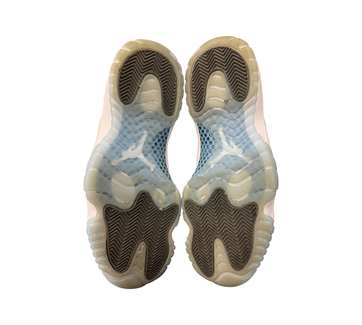 Genesis Boutique Jordan 11 Legend Blue sneakers showing the translucent blue and black herringbone traction outsoles