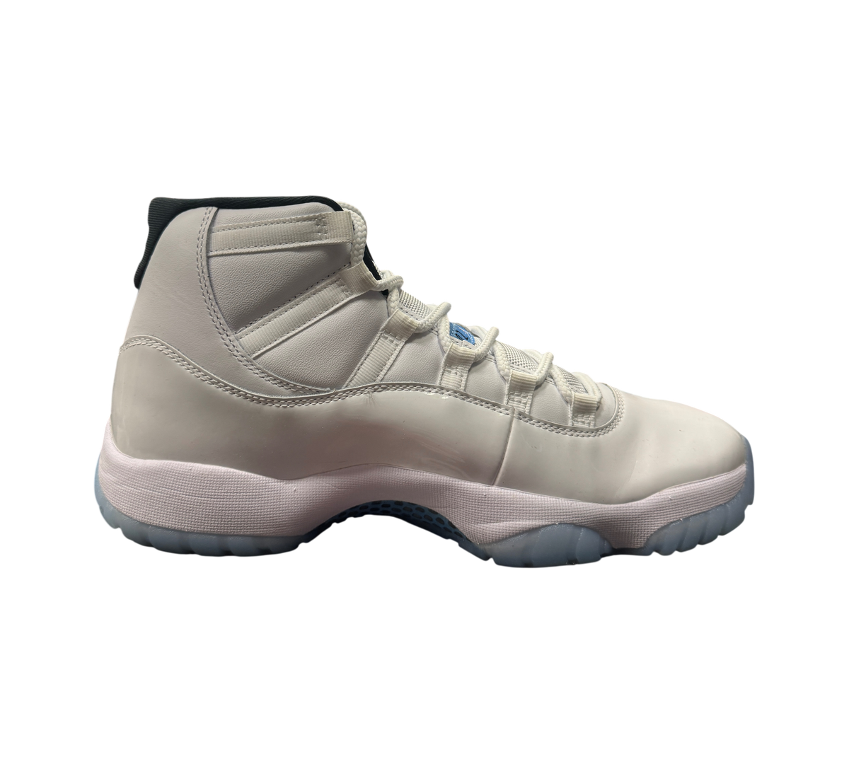 Genesis Boutique Jordan 11 Legend Blue sneaker in white patent leather with light blue accents on a display box