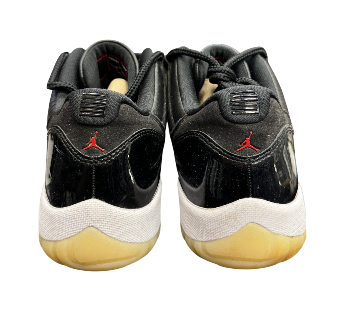 Genesis Boutique Jordan 11 Low 72-10 sneakers featuring black patent leather and red Jumpman logos on the heel