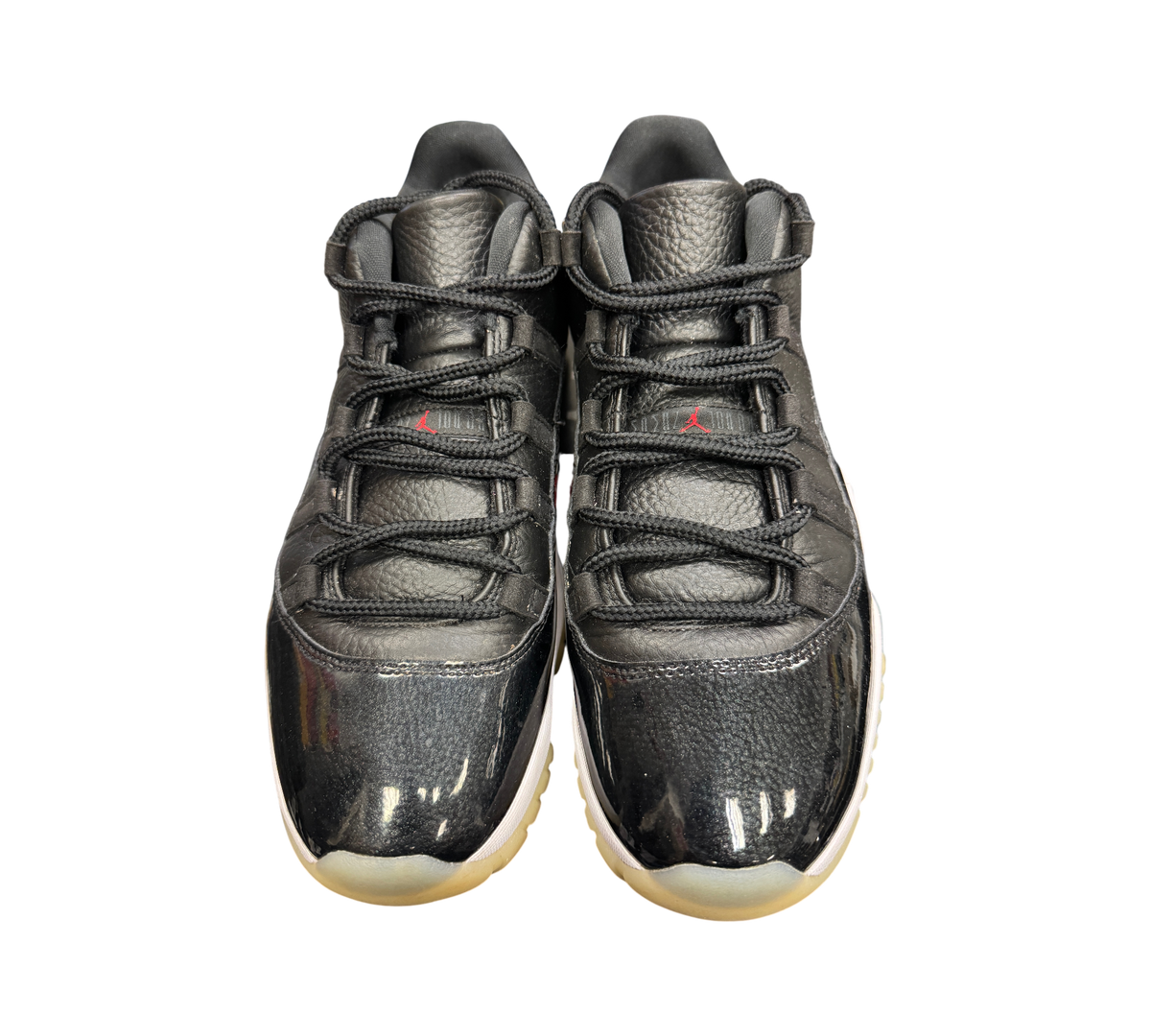 Genesis Boutique Jordan 11 Low 72-10 sneakers in black leather with patent leather mudguards and red branding details.