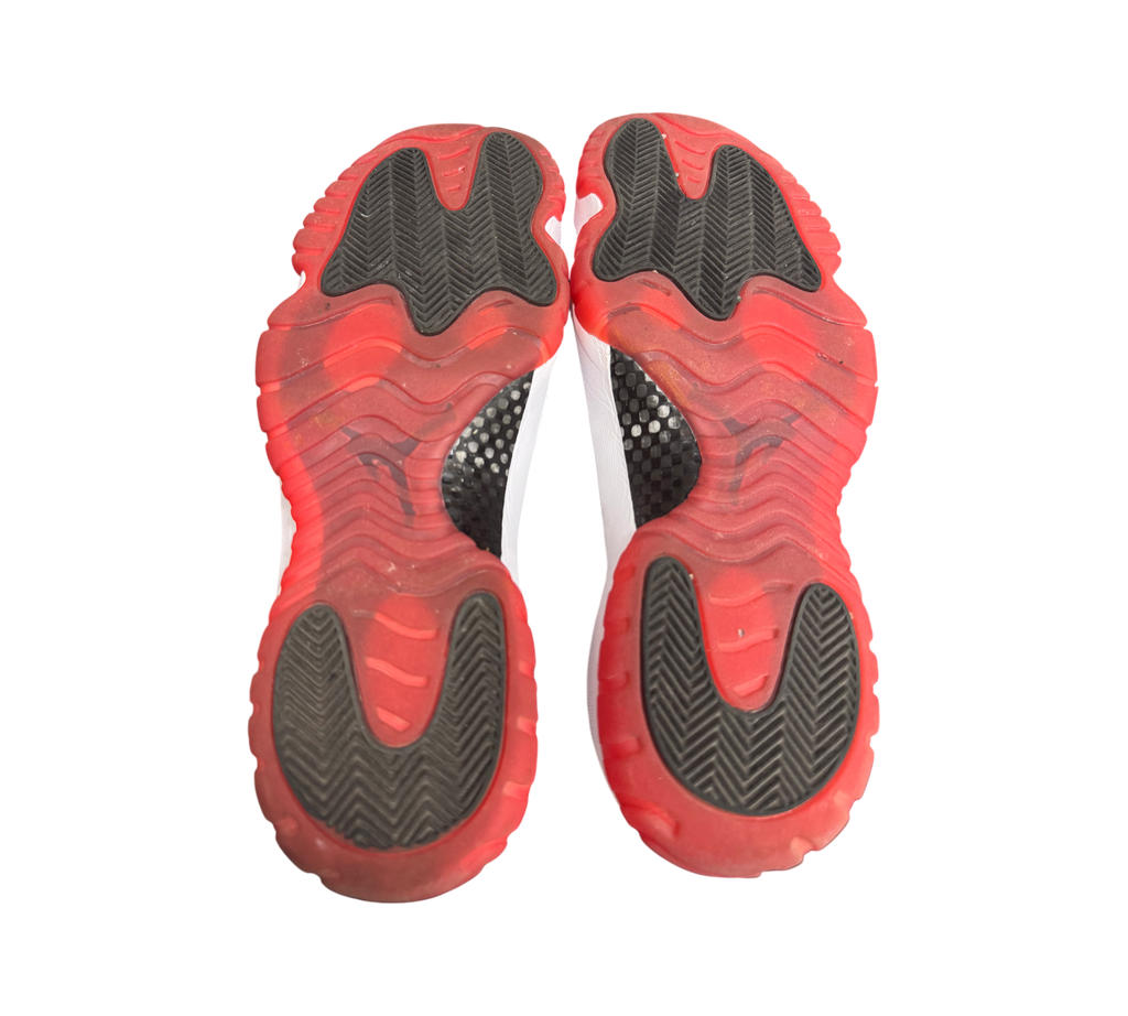 Genesis Boutique pre-owned Jordan 11 Low Bred sneakers showing the red and black translucent rubber outsoles.