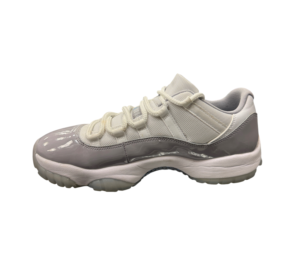 Genesis Boutique Jordan 11 Low Cement Grey sneakers featuring white mesh uppers and grey patent leather mudguards.