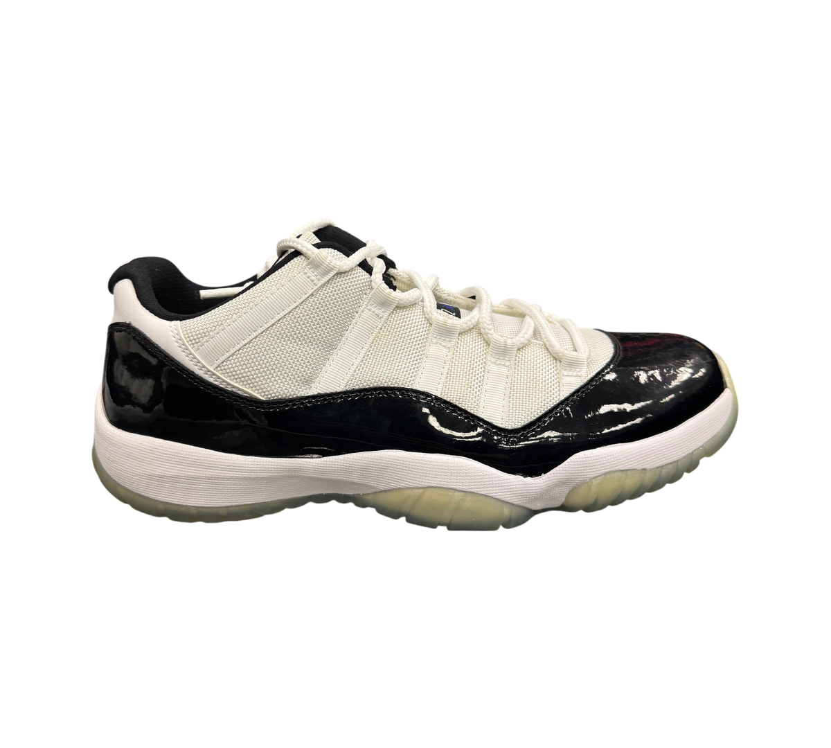 Genesis Boutique Jordan 11 Low Concord sneakers featuring white mesh upper, black patent leather, and translucent sole.