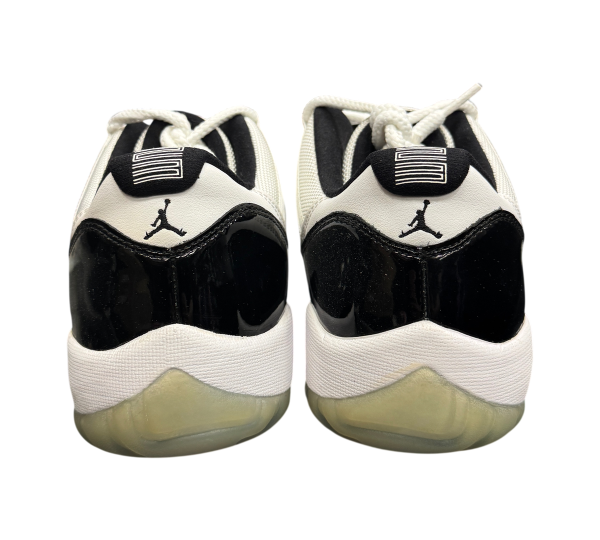 Genesis Boutique pre-owned Jordan 11 Low Concord sneakers featuring black patent leather and white mesh details.