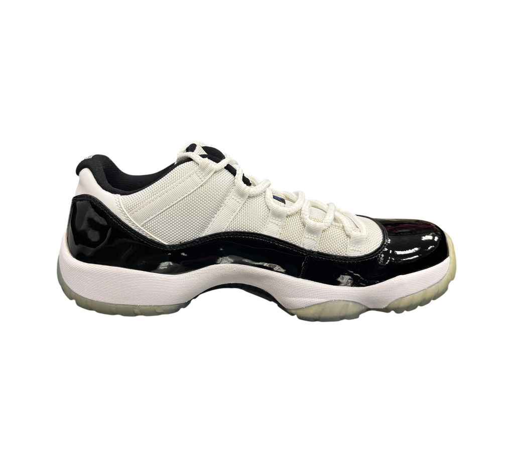Genesis Boutique Jordan 11 Low Concord sneaker in white and black patent leather with a translucent outsole.
