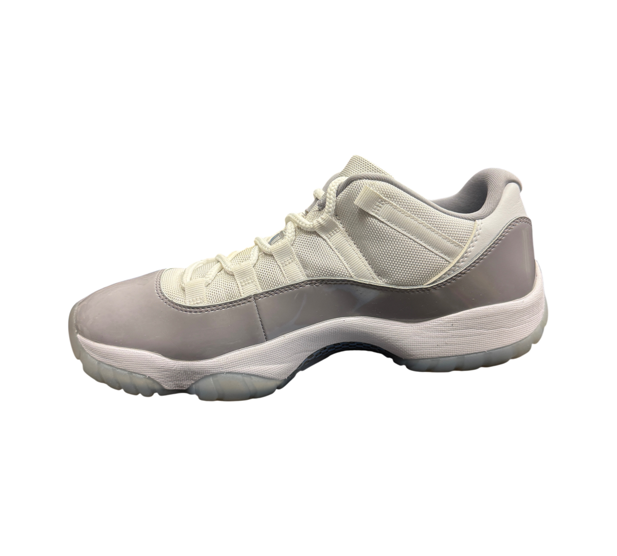 Genesis Boutique Jordan 11 Low Grey Cement sneakers featuring white mesh and grey patent leather on a Jordan box.