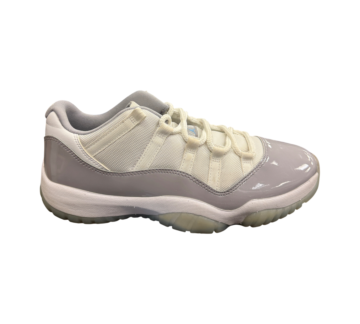 Genesis Boutique Jordan 11 Low Grey Cement sneakers featuring white mesh upper, grey patent leather, and icy outsole.