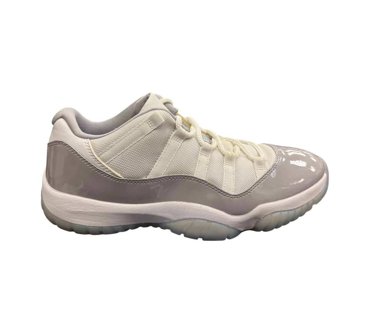 Genesis Boutique Jordan 11 Low Grey Cement sneakers with white mesh upper, grey patent leather, and translucent sole.