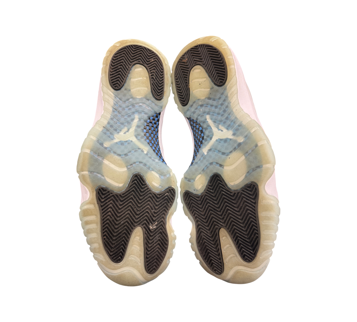 Genesis Boutique Jordan 11 Low Legend Blue sneakers showing the translucent blue and black herringbone rubber outsoles