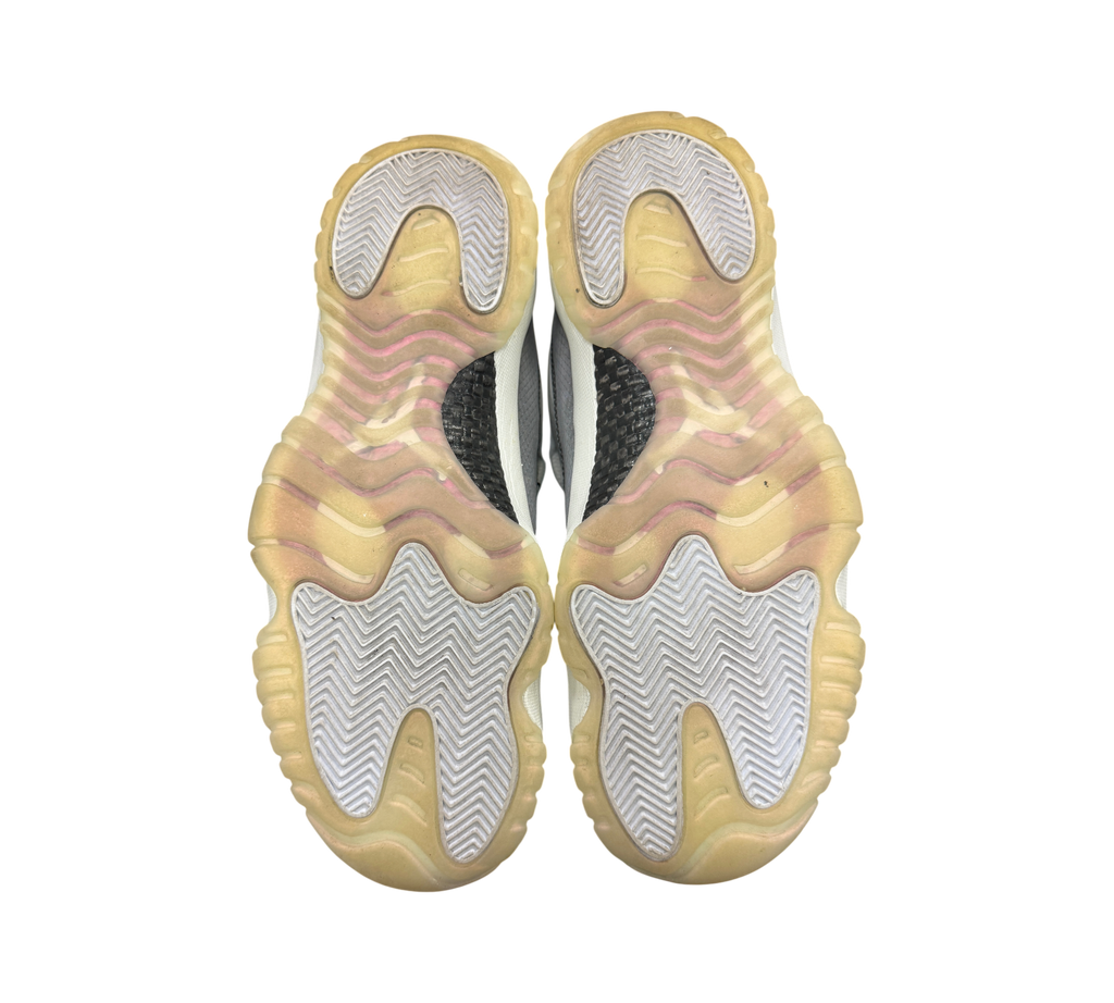 Genesis Boutique Jordan 11 Low Year of the Snake sneakers showing the yellowed translucent rubber outsoles