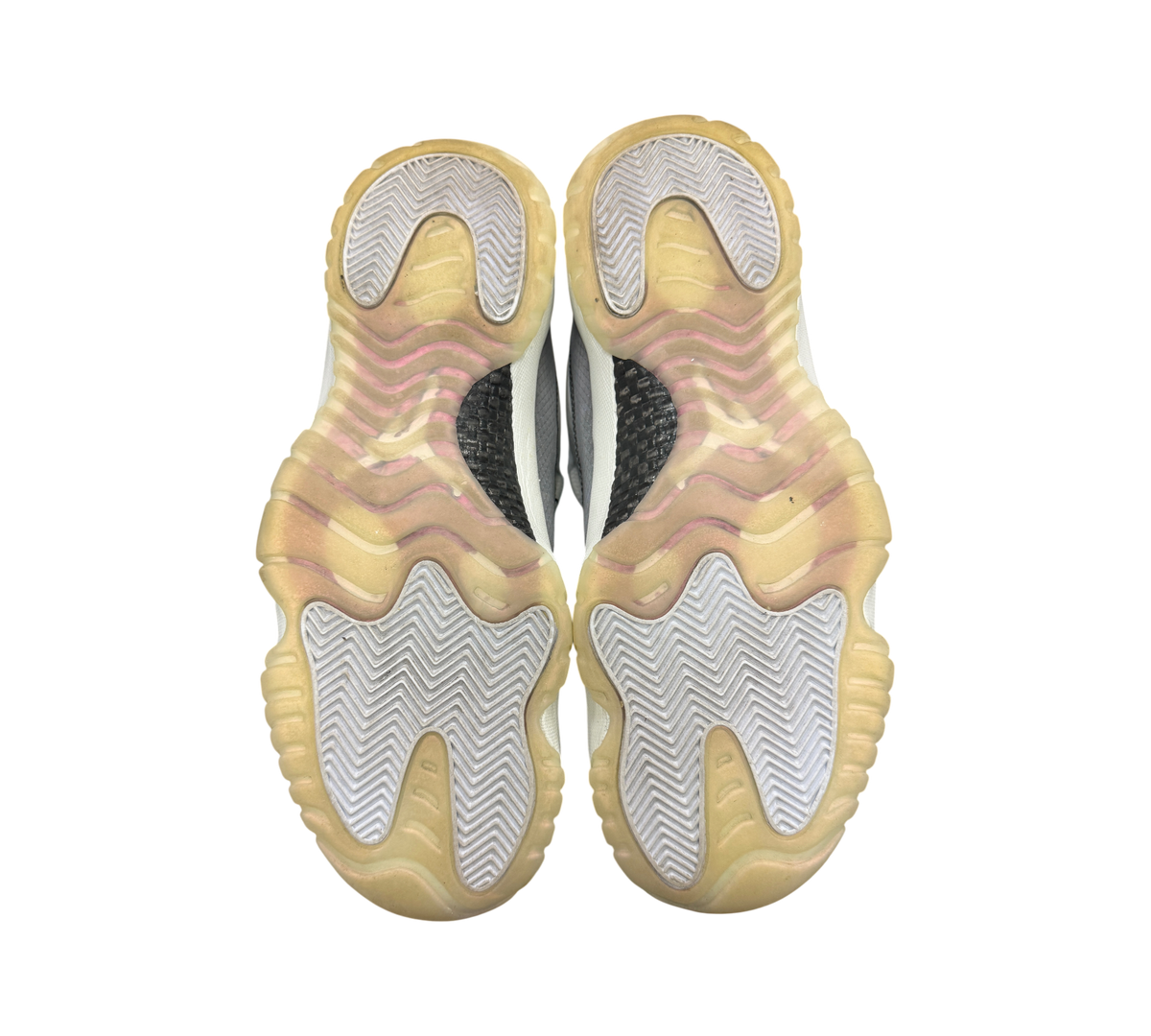 Genesis Boutique Jordan 11 Low Year of the Snake sneakers showing the yellowed translucent rubber outsoles