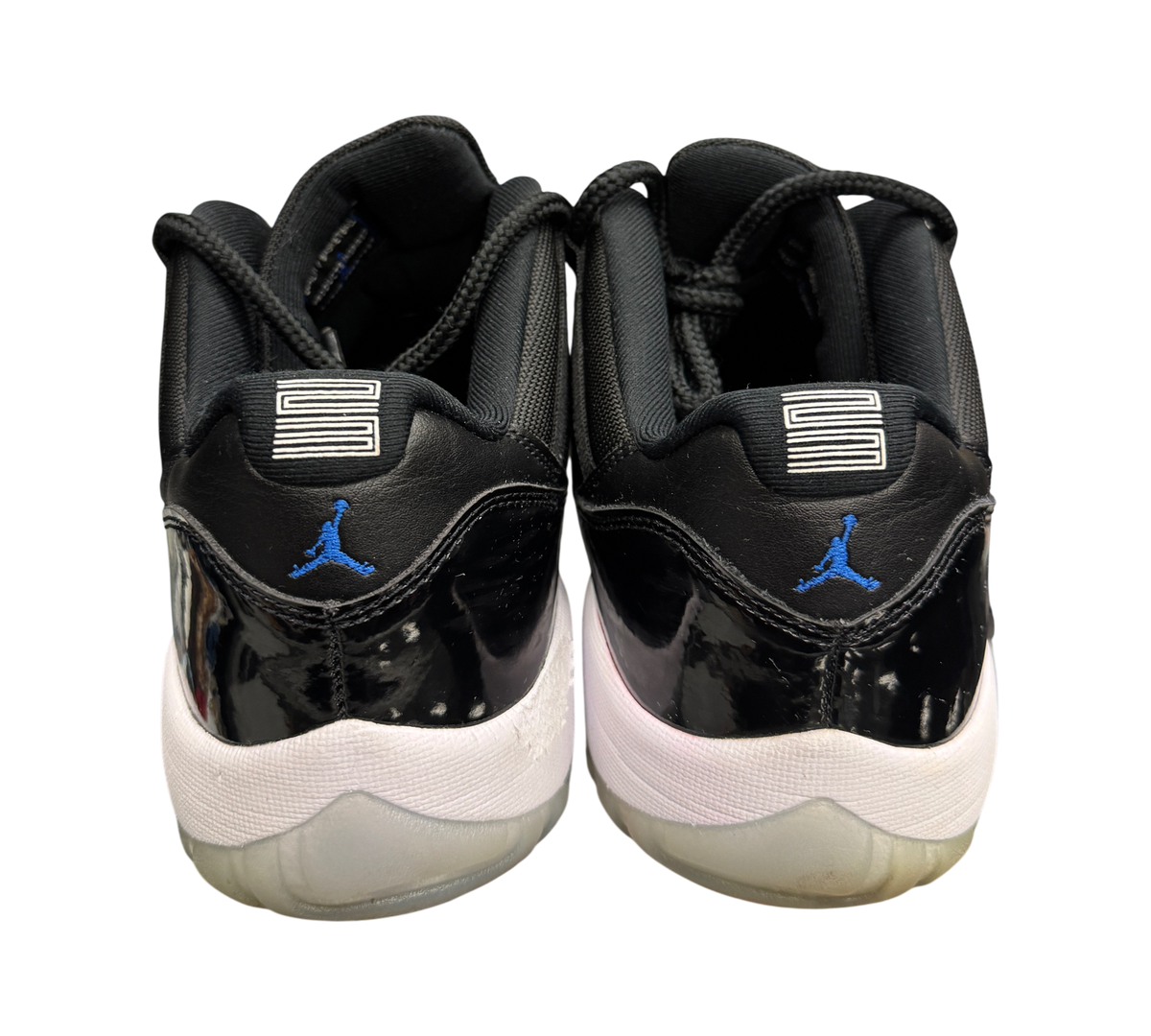 Genesis Boutique Jordan 11 Low Space Jam sneakers featuring black patent leather, blue Jumpman logo, and white midsole.