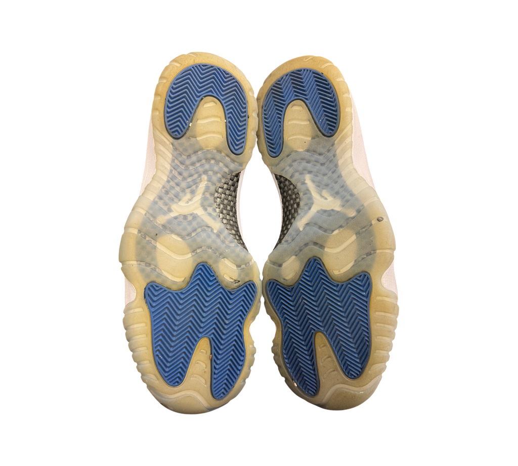 Genesis Boutique Jordan 11 Low Space Jam sneakers showing the blue and translucent rubber outsoles from below