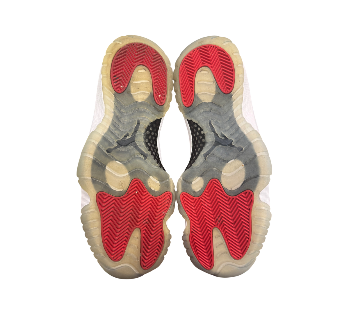 Genesis Boutique Jordan 11 Win Like 96 sneakers showing red and translucent rubber outsoles with herringbone traction