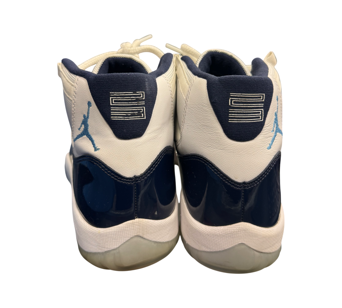 Genesis Boutique Jordan 11 "Win Like 82" shoes with white leather, navy patent leather, and light blue accents.