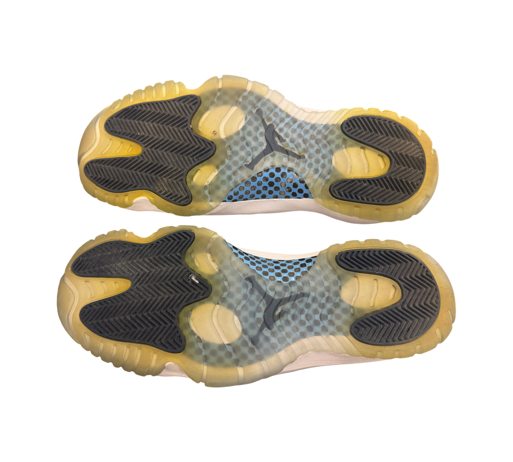 Genesis Boutique Jordan 11 "Win Like 82" shoes, white with translucent yellowed soles and blue accents.