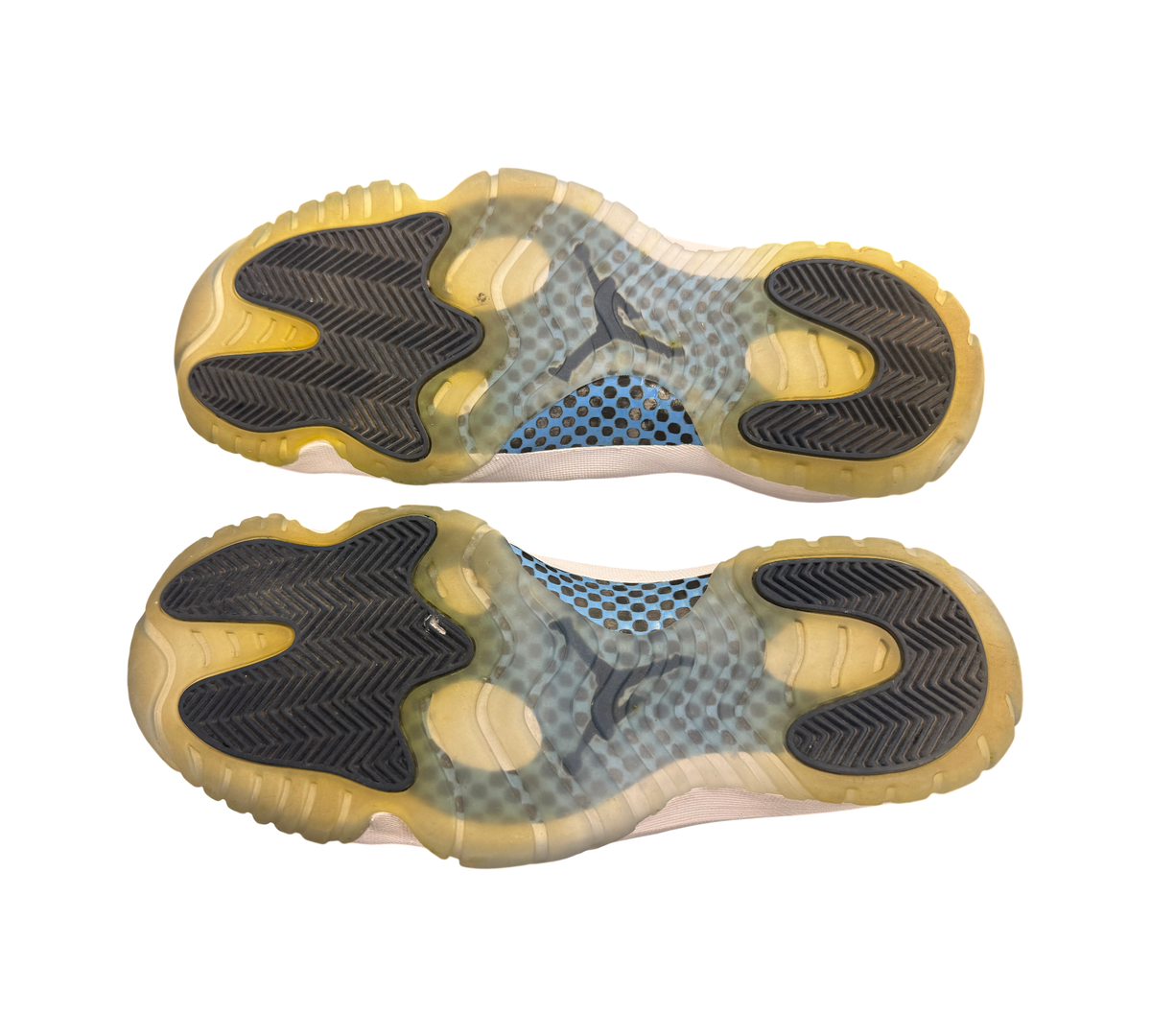 Genesis Boutique Jordan 11 "Win Like 82" shoes, white with translucent yellowed soles and blue accents.