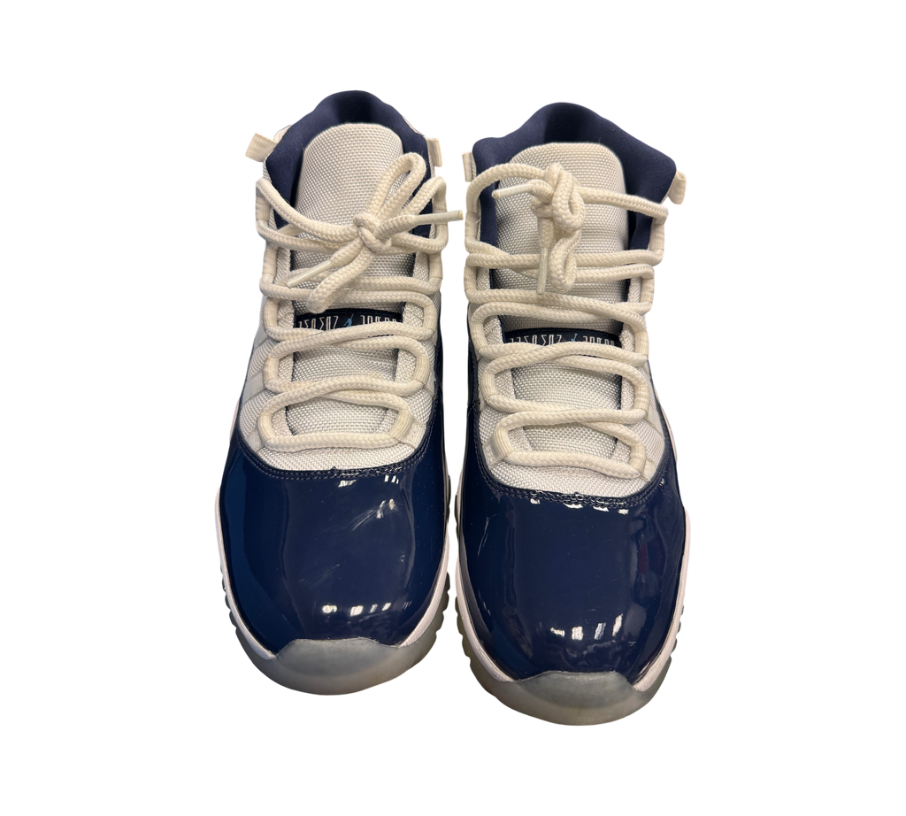 Genesis Boutique Jordan 11 "Win Like 82" sneakers in white and navy blue patent leather with white laces.