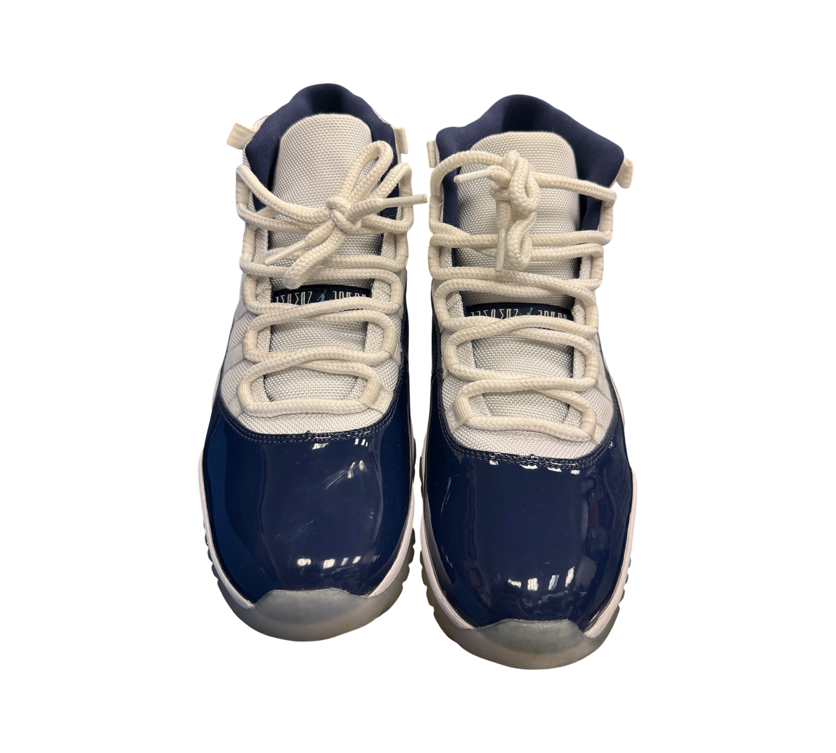 Genesis Boutique Jordan 11 "Win Like 82" sneakers in white and navy blue patent leather with white laces.