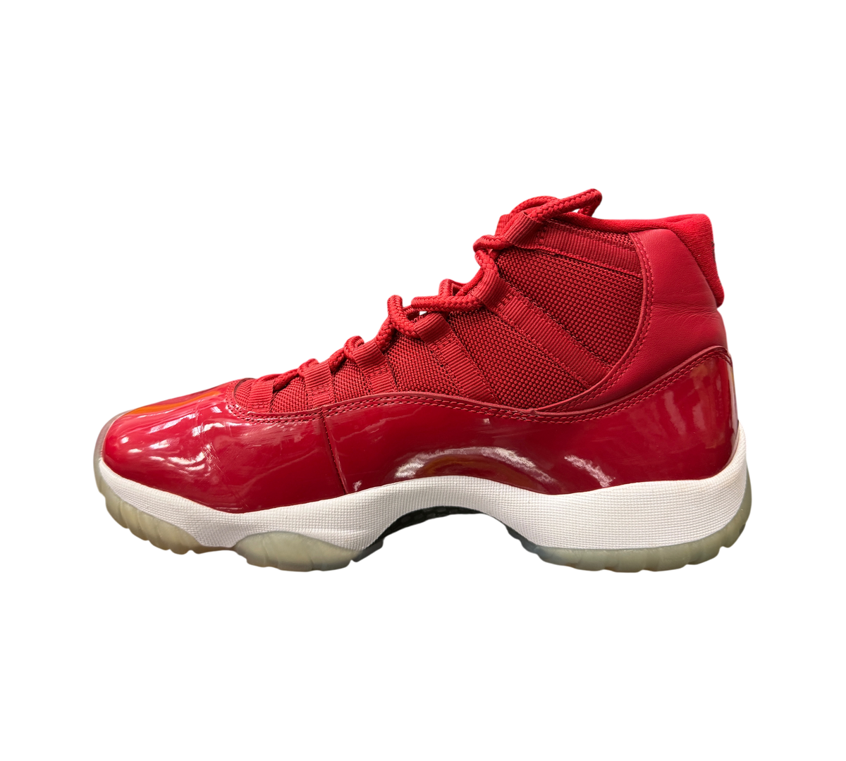 Genesis Boutique Jordan 11 Win Like 96 sneakers in gym red with patent leather and mesh upper on a glass display
