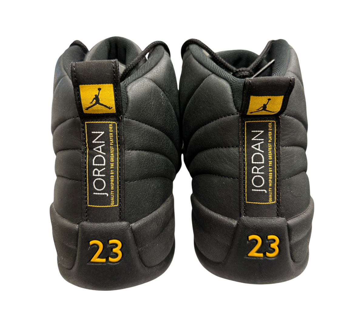 Genesis Boutique Jordan 12 Black Taxi sneakers featuring black leather uppers with yellow 23 and Jumpman heel details.