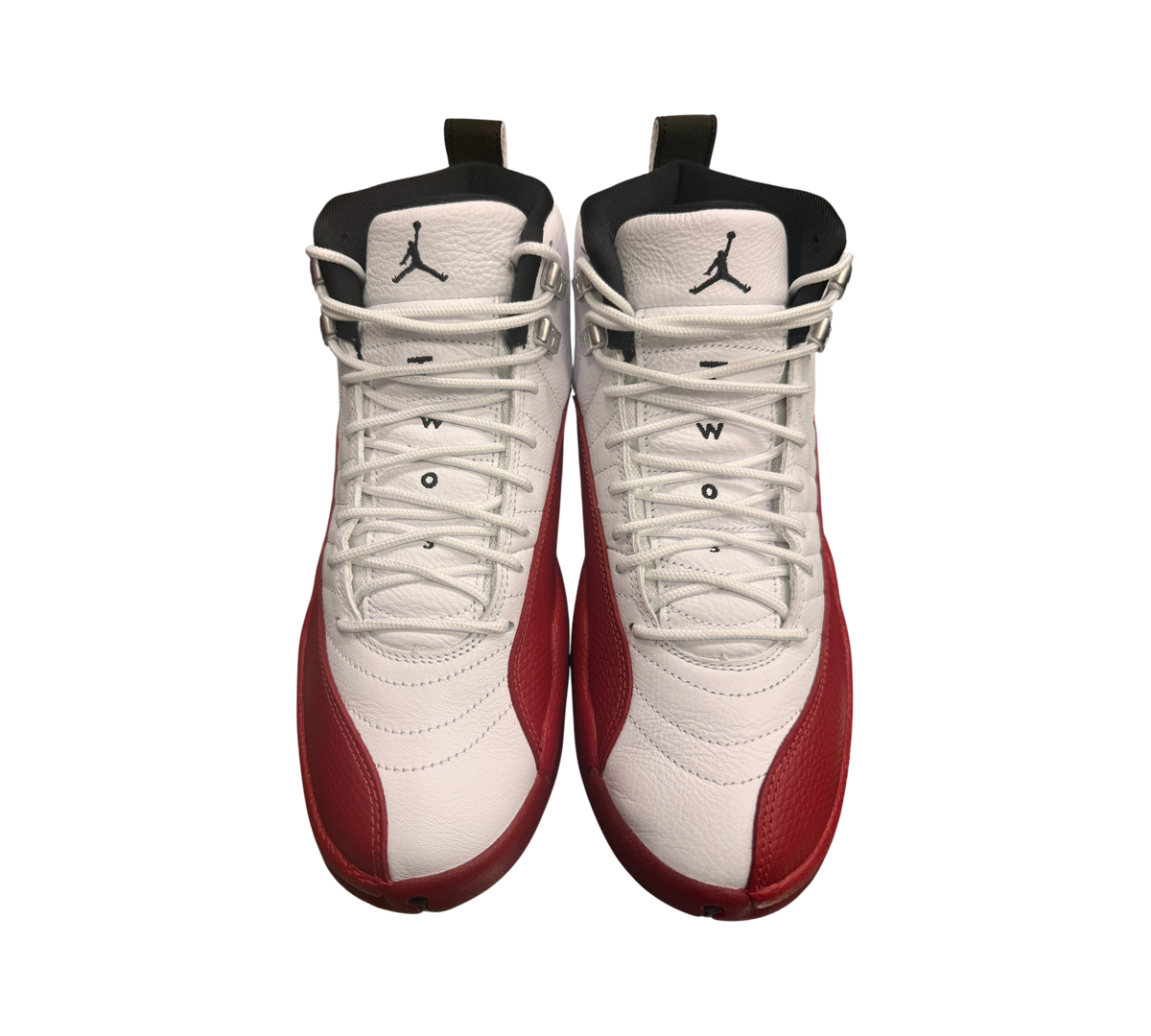 Genesis Boutique white leather Jordan 12 Cherry 2023 sneakers with red overlays and black accents.