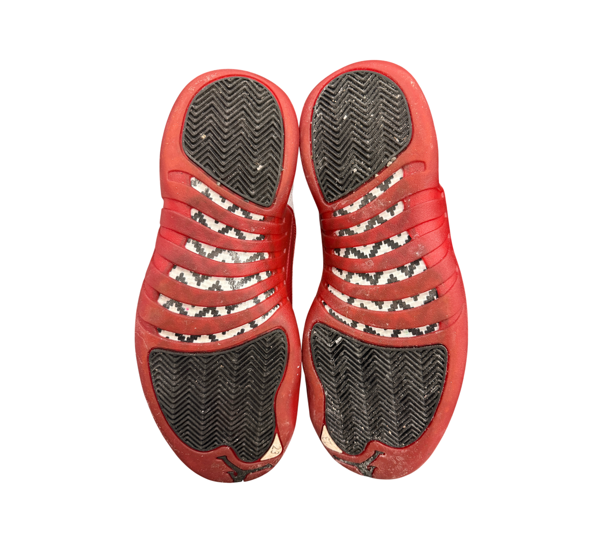 Genesis Boutique used Jordan 12 Cherry sneakers showing red and black herringbone traction outsoles and carbon fiber