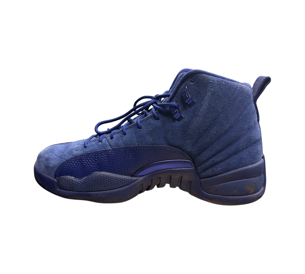 Genesis Boutique Jordan 12 Deep Royal Blue suede sneakers with textured overlays and blue laces.