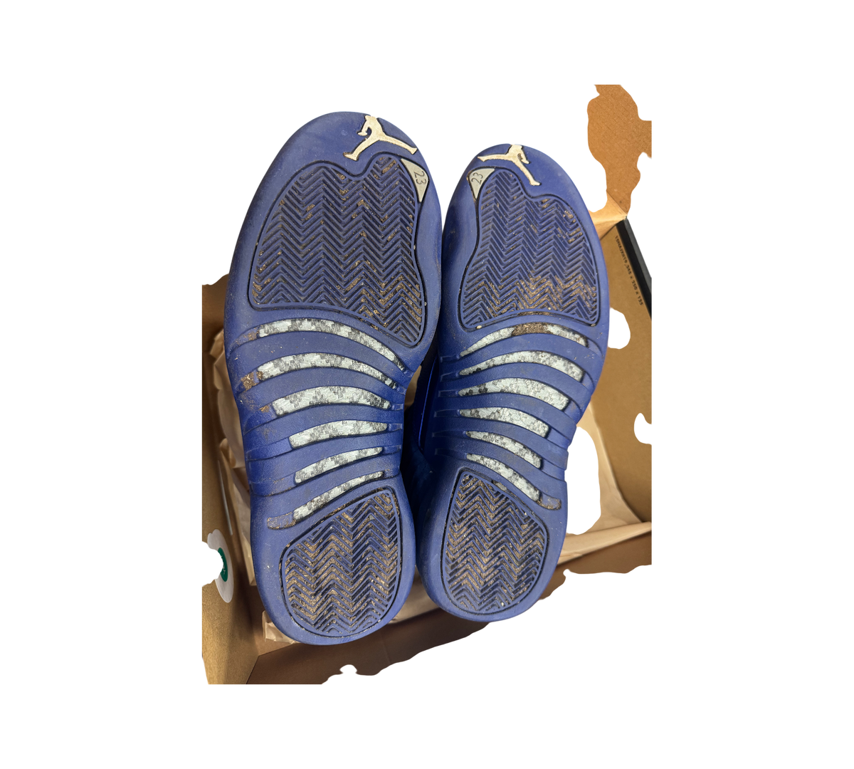 Genesis Boutique Jordan 12 Deep Royal Blue sneakers, showing the blue soles with white Jumpman logo and "23" detail.
