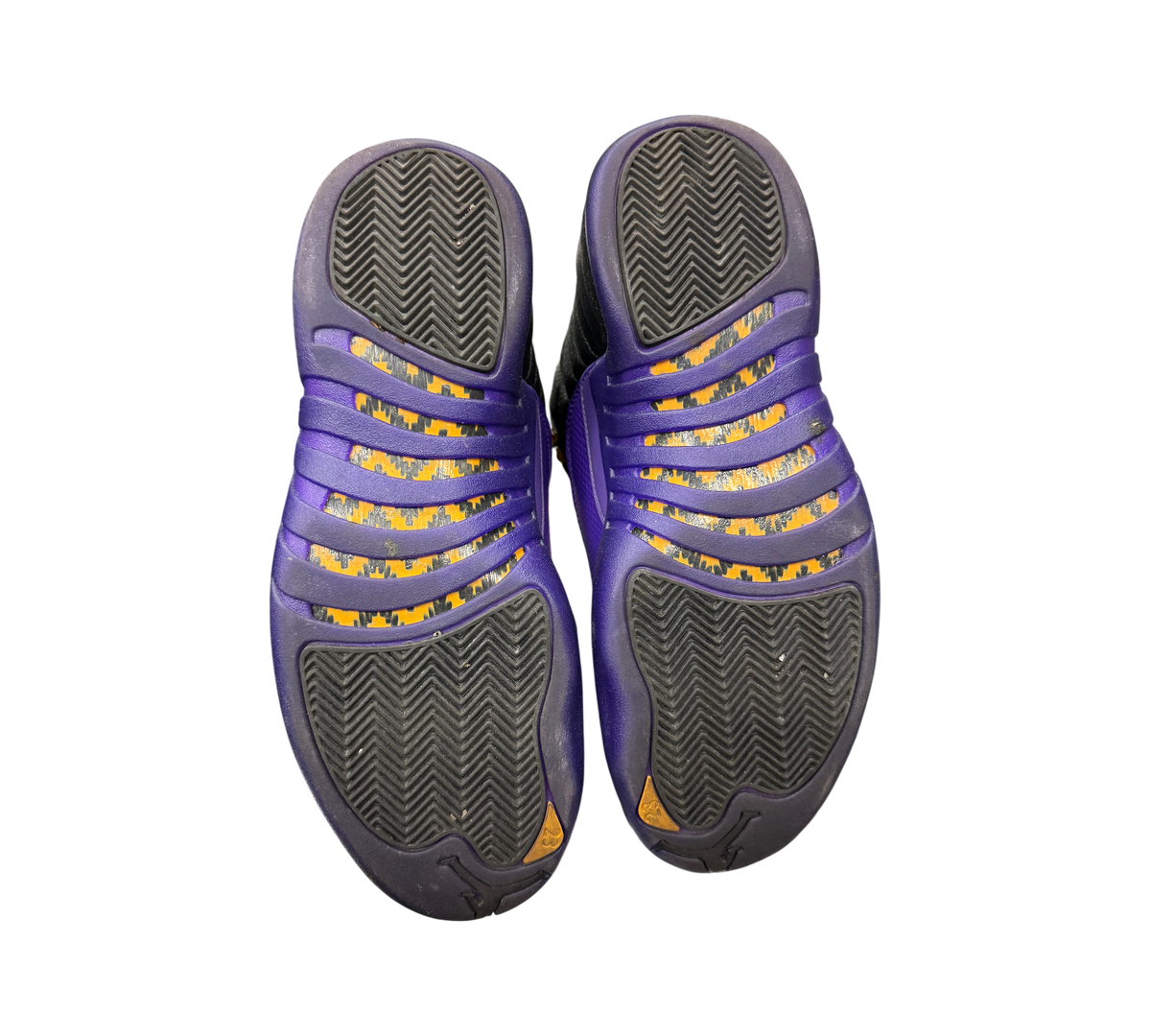 Genesis Boutique used Jordan 12 Field Purple sneakers showing the black and purple herringbone traction outsoles.