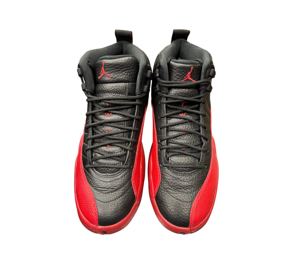 Genesis Boutique Jordan 12 Flu Game 2025 sneakers in black and red leather with iconic textured mudguard design.