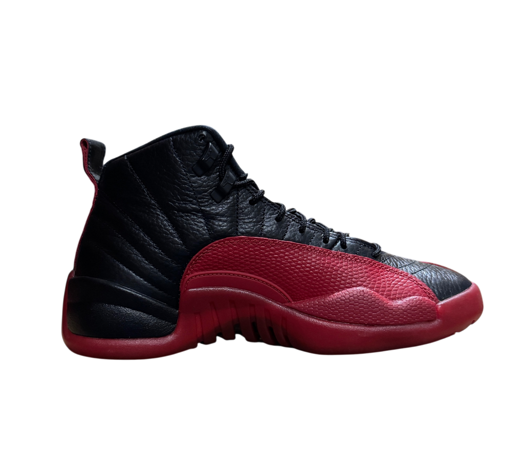 Genesis Boutique Jordan 12 Flu Game sneakers in black and red leather with textured mudguard, side profile view.