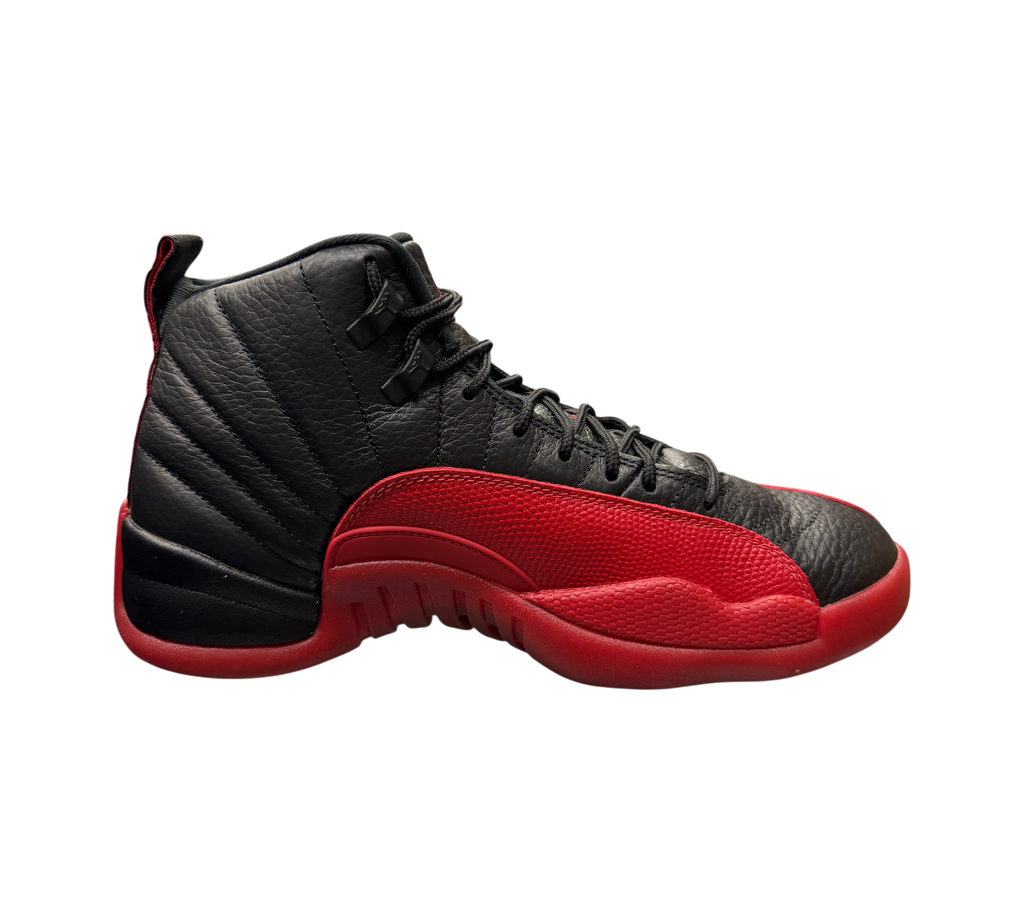 Genesis Boutique Jordan 12 Flu Game 2025 sneakers in black and red leather displayed on a glass shelf in a store