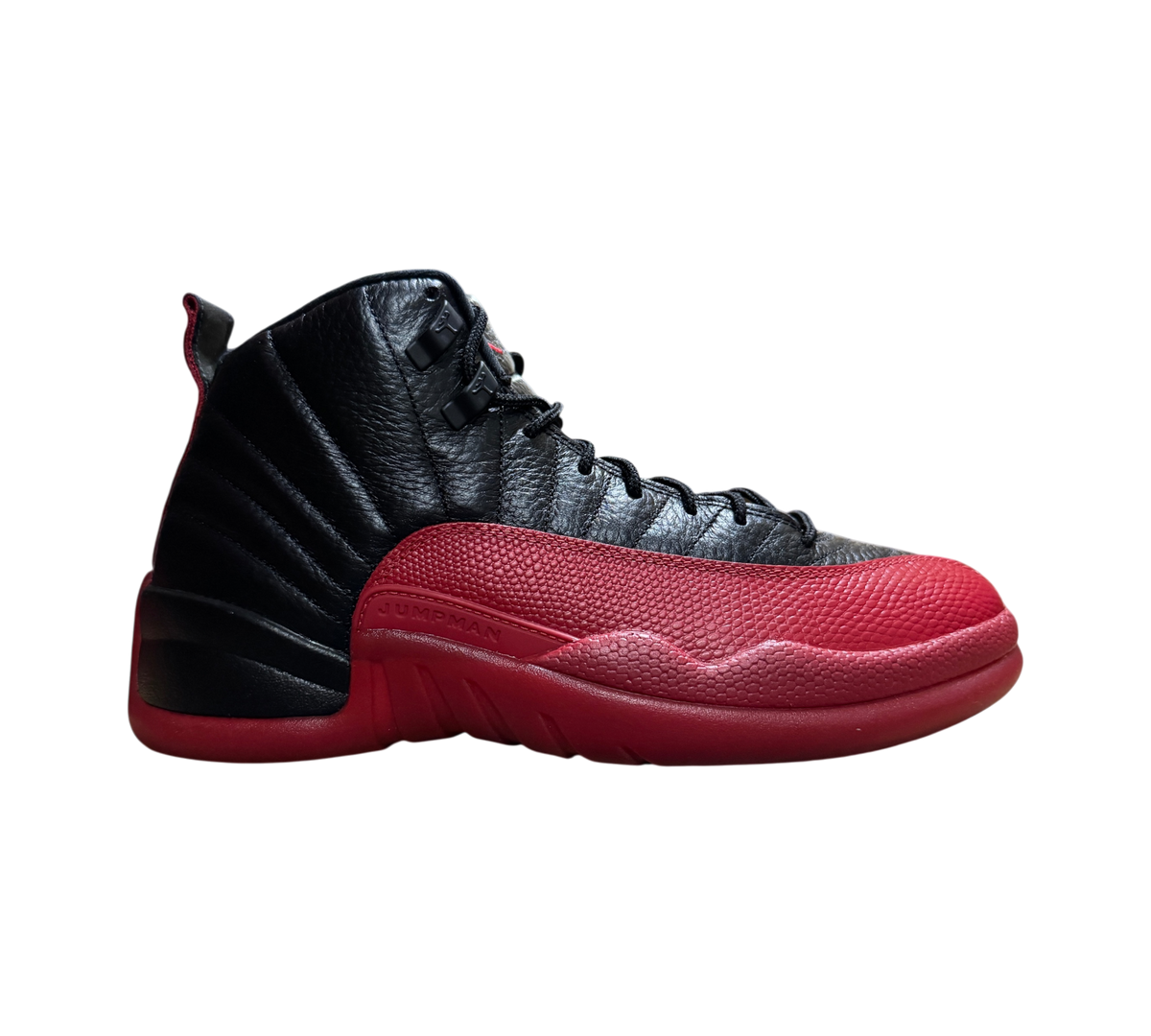 Genesis Boutique Jordan 12 Flu Game sneakers in black and red leather with textured mudguard side profile view