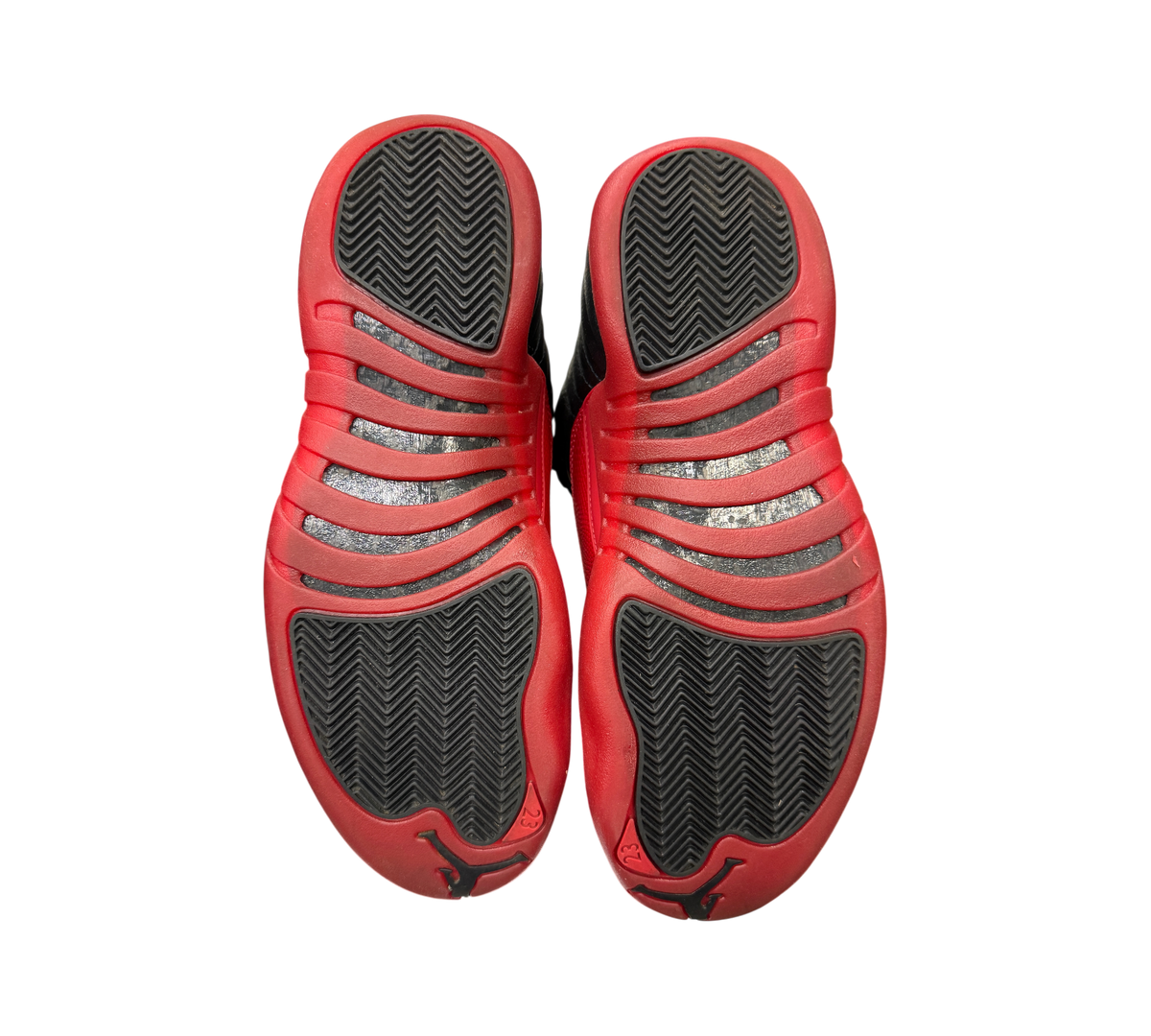 Genesis Boutique Jordan 12 Flu Game 2025 sneakers showing black and red rubber outsoles with herringbone traction
